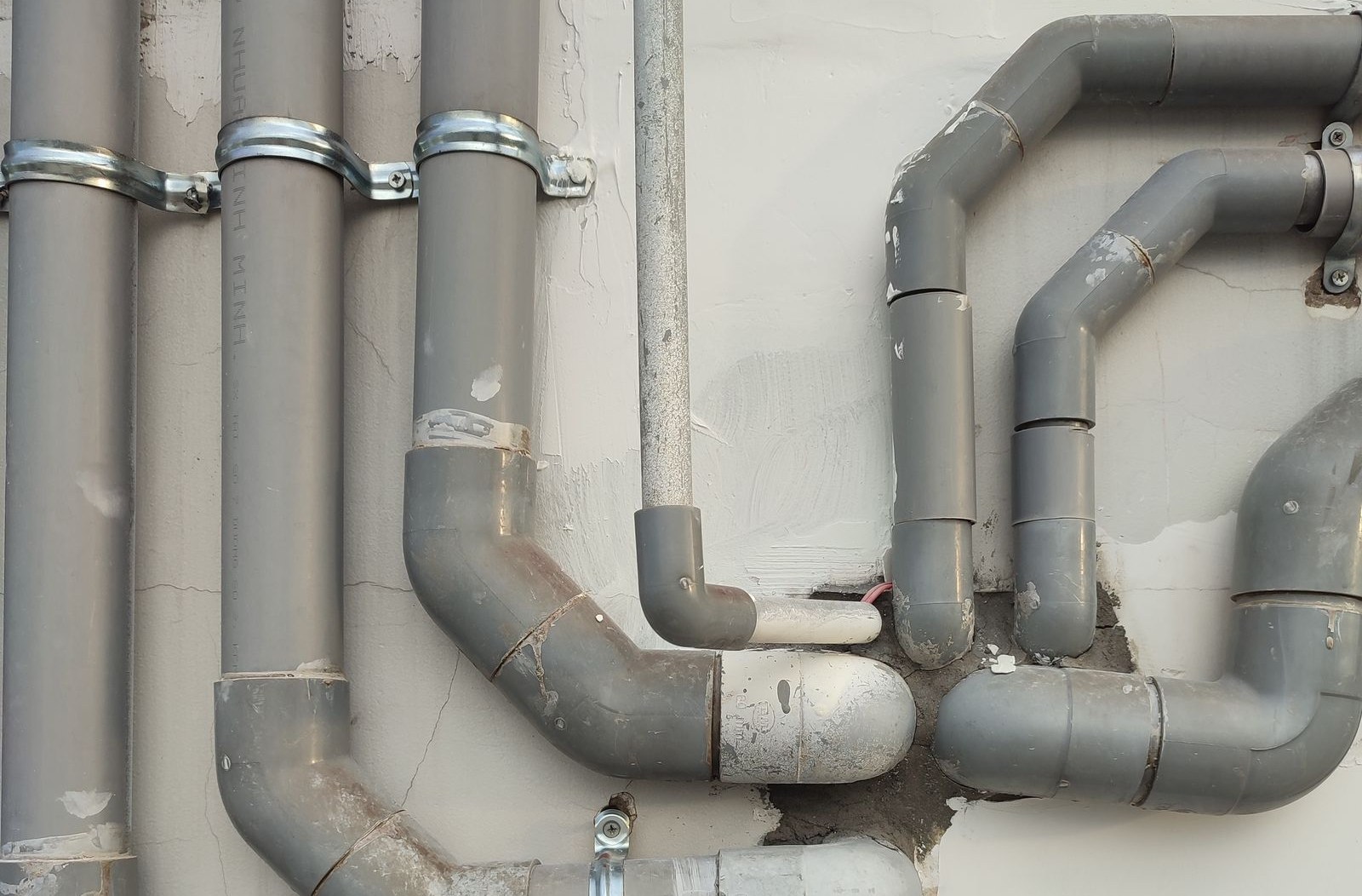 New PVC piping runs installed on a wall, clamped, level and to code